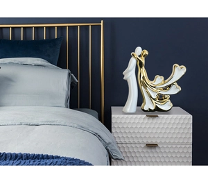 Détail d'une figurine de couple en céramique blanche et dorée pour décoration moderne
