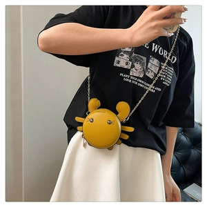 Chic yellow crab crossbody bag with metal chain strap shown in a lifestyle model shot