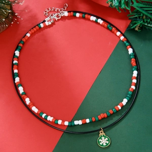 Detail of Christmas beaded necklace featuring a green snowflake charm and festive color beads