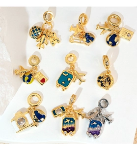 Detailed travel charms featuring gold airplane, suitcase, and globe with zircon inlays