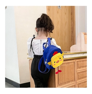 Rear view of a young girl wearing a blue canvas backpack with a yellow chick cartoon pocket