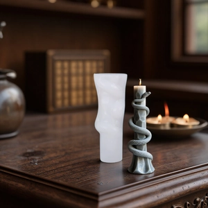 DIY snake-shaped silicone candle mold and finished grey wax sculpture on wooden base
