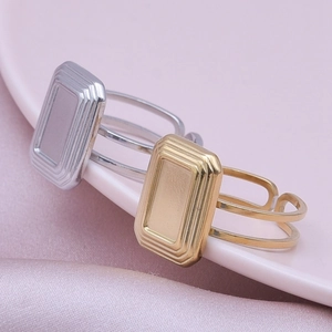 Close-up of gold and silver layered open rings on a pink decorative plate