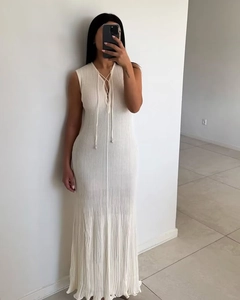 Detail of elegant cream-white knitted maxi dress with lace-up neckline and slim fit silhouette