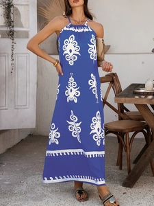 Detail des blauen Neckholder-Kleides mit weißem Boho-Print und wellenförmigem Saum