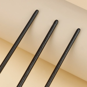 Set of 3 sleek black nail art brushes with smooth glossy finish on beige background