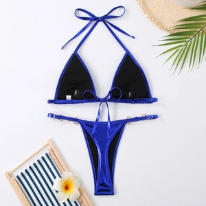 Vue détaillée à plat du bikini bleu métallisé avec anneaux dorés et accessoires d'été
