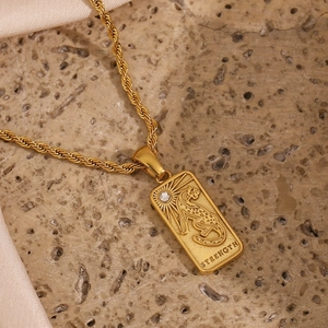 Detail of 18K gold-plated tarot pendant with leopard engraving and strength text