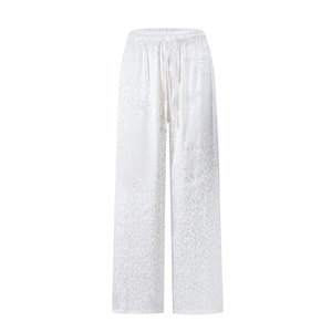 Detail of high-waisted white wide-leg pants with subtle leopard jacquard pattern