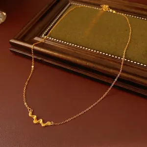 Vintage brushed gold wavy necklace with delicate cross chain on deep red leather surface
