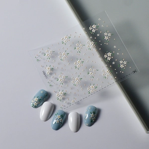 Detailed 5D embossed nail stickers featuring white daisies and green leaves on nails