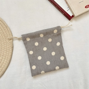Detailed view of a gray corduroy drawstring pouch with white polka dots for small storage