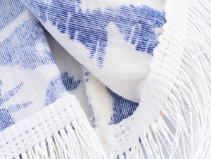 Détail de la frange en dentelle bohème bleue et blanche sur une robe longue licou