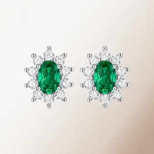 Close-up of green oval gemstone earrings with white diamond halo in silver setting