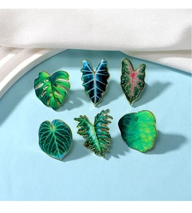 Set of six tropical leaf enamel pins featuring monstera and taro designs in soft colors