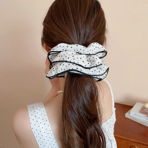 Detailed back view of a white chiffon scrunchie with black polka dots on a high ponytail