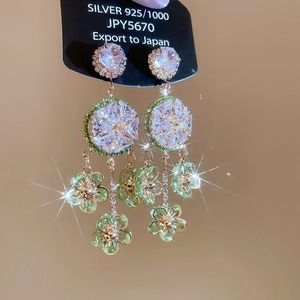 Detailed shot of 925 silver earrings with green floral crystals and zircon tassels