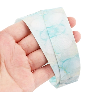 Macro shot of blue and white marble pattern ribbon with gold speckles and silk texture