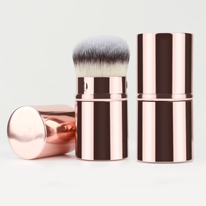 Portable retractable makeup brush in rose gold metal with soft dual-tone bristles