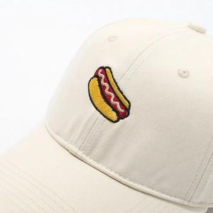 Close-up of hot dog embroidery on a beige cotton baseball cap with twill texture