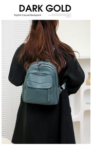Morandi green pebbled leather backpack with rivets shown on a model for size perspective
