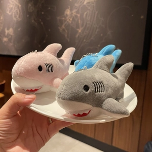 Close-up of cute plush shark keychains in pink and grey colors with metal hanging chains