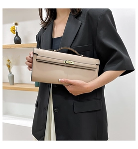 Detail showing beige leather clutch bag with elegant gold hardware and secure clasp closure