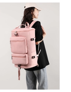 Model wearing a large pink fitness travel bag with dry-wet separation and side buckles