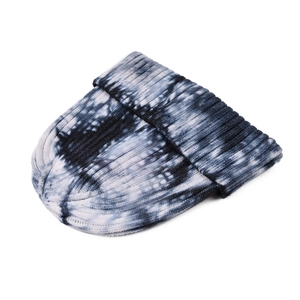 Détail du bonnet en tricot tie-dye bleu, noir et blanc avec motifs ondulés et côtes