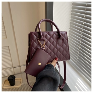 Detail of wine red quilted handbag featuring PU leather texture and matching coin purse