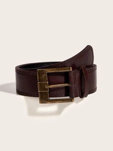 Detail of vintage dark brown leather belt featuring bronze metal buckle and stitching