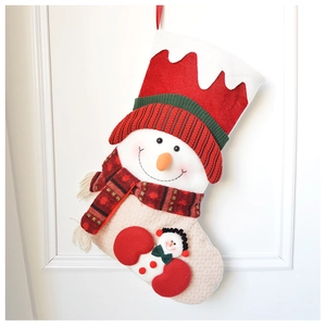 Close-up of knit Christmas stocking with 3D plush snowman and vibrant red velvet cuff