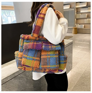 Side view of large plaid faux fur tote bag in colorful check pattern on model's shoulder