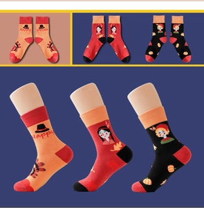 Detail of knitted mid-calf socks with pumpkin and turkey patterns for Thanksgiving