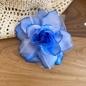 Gros plan de la pince à cheveux fleur en gaze bleue avec des pétales vaporeux et fins
