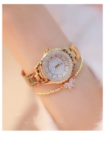Close-up of gold tone women's watch with iced-out crystal dial and butterfly bracelet