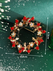 Detailed view of a Christmas wreath brooch with red and green crystals, 4.3cm size