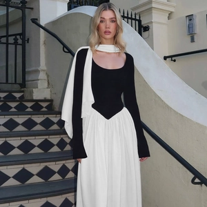 Detailed view of fashionable black and white contrast long-sleeve dress on outdoor stairs