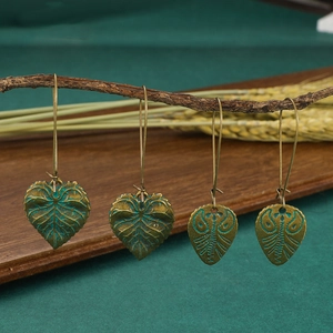 Boucles d'oreilles vintage en forme de feuille verte avec texture sur branche en bois