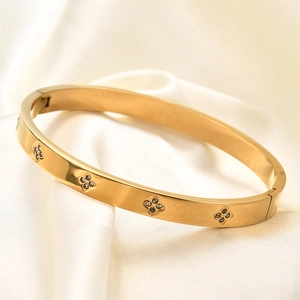 Detail van de 6mm goudkleurige armband met klavermotieven en kristallen inlegwerk
