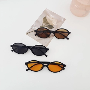 Three oval minimalist sunglasses in black frames with grey brown and orange lenses