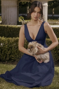 Detailed view of navy blue V-neck maxi dress with flowy skirt on outdoor grass