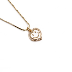 Gold plated heart pendant necklace with white enamel smiley face and zircon crystals