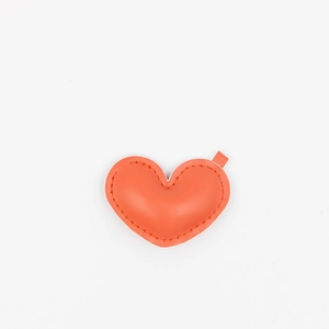 Detail shot of an orange PU leather heart keychain with fine stitching and a gold loop