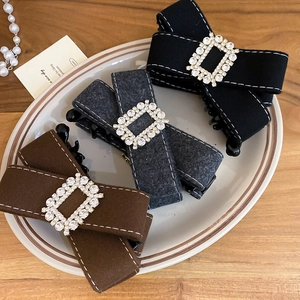 Detail of fabric bow hair clips with square rhinestones in black, grey, and coffee colors