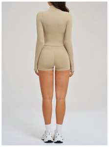 Vista posteriore di un set yoga nude con top a collo alto e pantaloncini abbinati