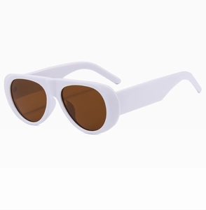 Detail view of thick white frame and brown lenses on retro oversized aviator sunglasses