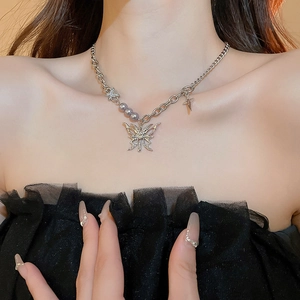 Close-up of lava butterfly pendant necklace with pearls on a model's collarbone