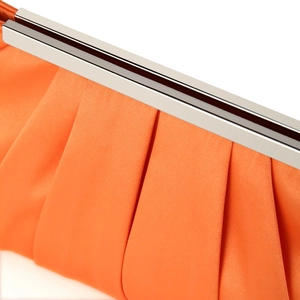 Detail of the orange pleated satin evening clutch with its silver metal frame closure