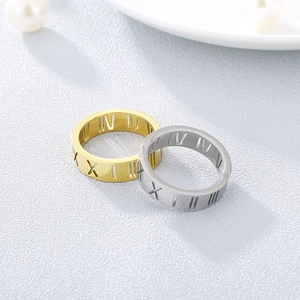 Detailed view of hollow Roman numeral rings in gold and silver titanium steel